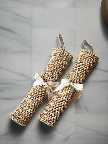 Two beige hemp washcloths with ribbons on a white background