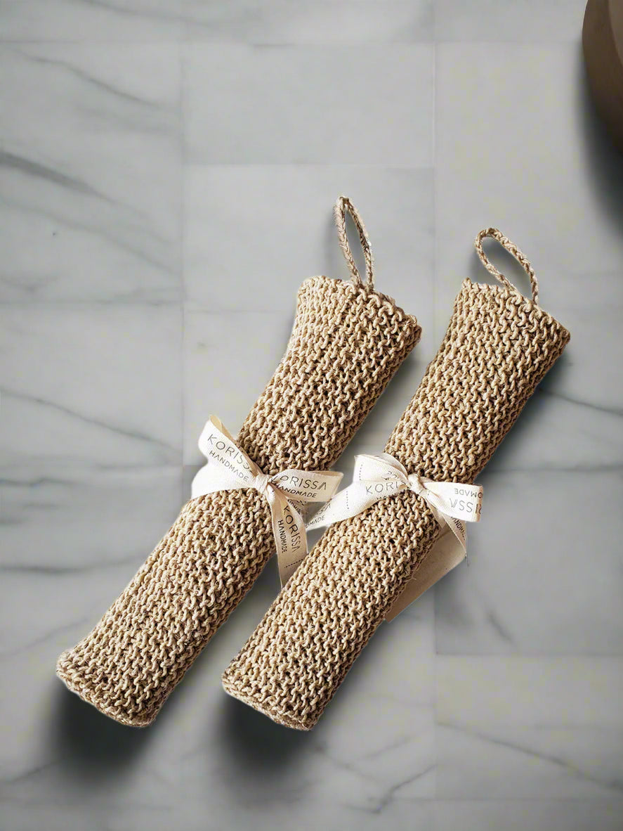 Two beige hemp washcloths with ribbons on a white background