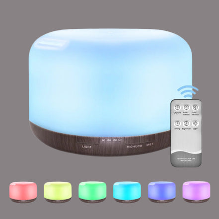 Aromatherapy diffuser with color-changing lights and a remote control on a white background