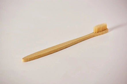 Bamboo toothbrush on a light gray background
