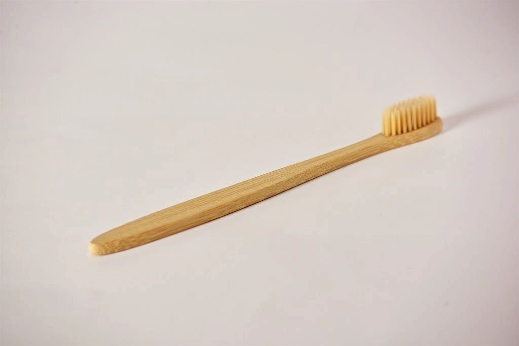 Bamboo toothbrush on a light gray background