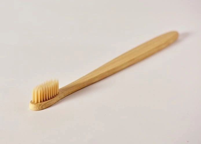 Bamboo toothbrush on a light gray background