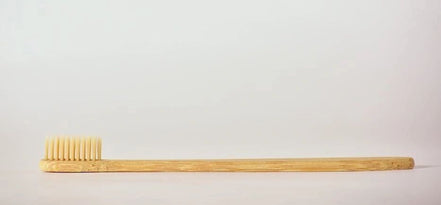 Bamboo toothbrush on a light gray background